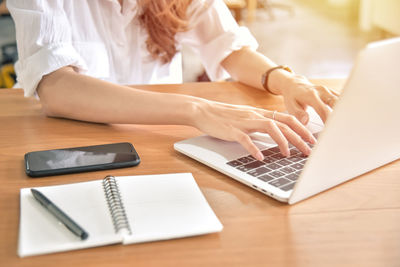 High angle view of woman using laptop on table