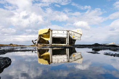 Abandoned boat in lake against sky