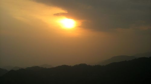 Scenic view of silhouette mountains against sky at sunset