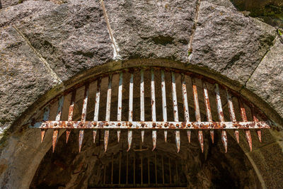 Low angle view of metal window on rock