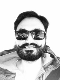 Portrait of man wearing sunglasses against white background