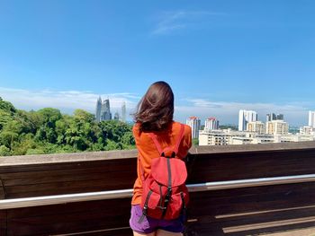 Rear view of woman looking at cityscape