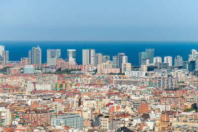 Aerial view of buildings in city against clear sky