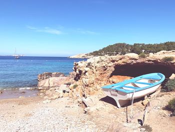Deck chairs on beach against blue sky