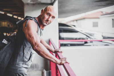 Side view of muscular man leaning on railing