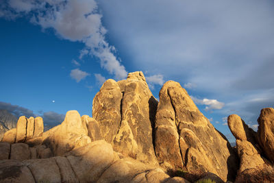 Morning sunshine on desert rock formations with white clouds in blue sky