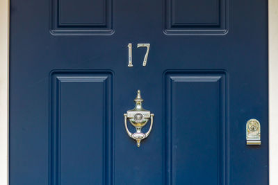House number 17 on a blue wooden front door in london 