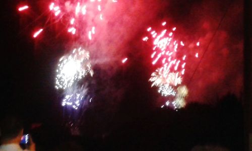 Low angle view of firework display at night