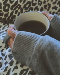 Low section of woman holding coffee cup