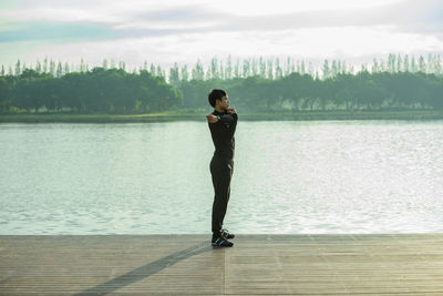 Full length of woman standing in lake against sky