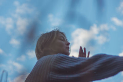 Low angle portrait of woman against sky