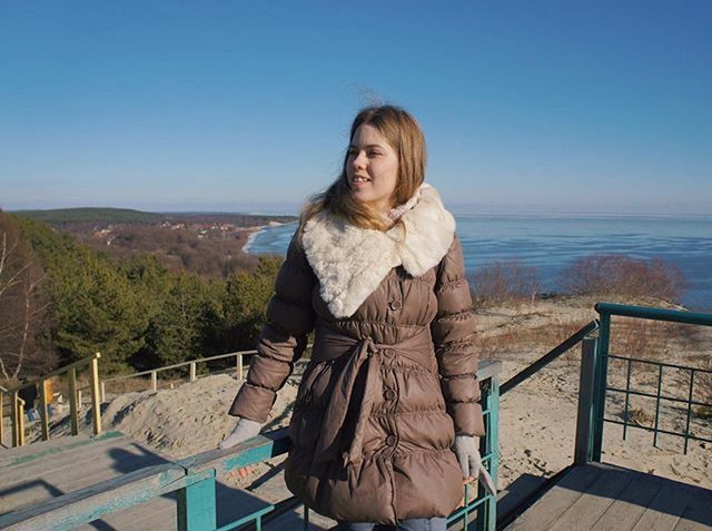 clear sky, person, young adult, casual clothing, lifestyles, looking at camera, portrait, leisure activity, standing, water, copy space, front view, railing, smiling, sitting, sea, young women, waist up