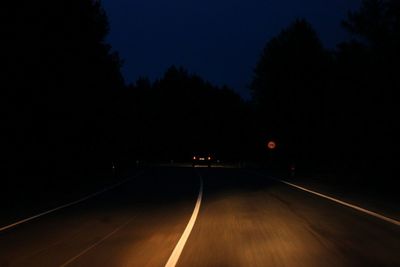 Empty road against sky at night