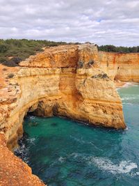 Scenic view of rock formation in sea against sky