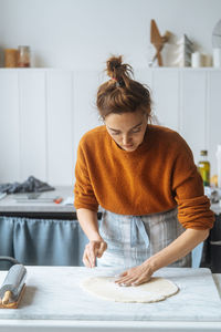 Midsection of woman with arms raised at home