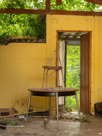 Chair over an old table in an abandoned room full of dirt.