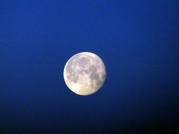 Low angle view of moon against blue sky