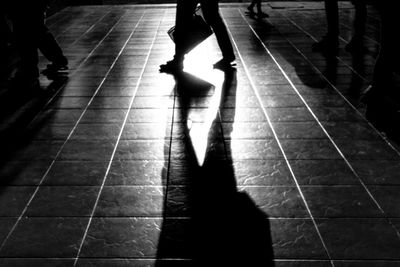 Low section of people standing on tiled floor