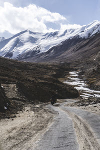 Tourist riding an adventure motorcycle on tuff and bumpy road on rock mountain in sunset lightning