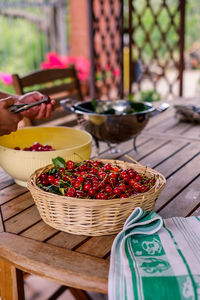 Cherries in wicker basket on table at home