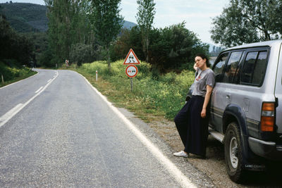 Man on road against trees