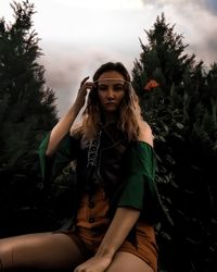 Portrait of beautiful woman against trees against sky