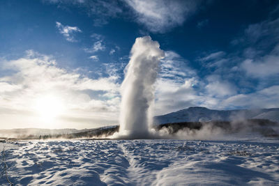 View of waterfall against cloudy sky