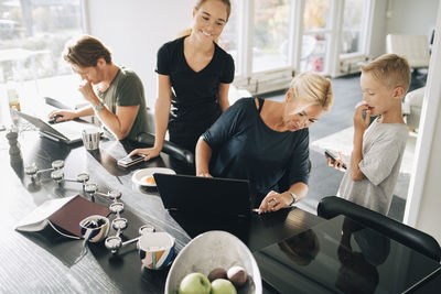 Group of people using phone while sitting on table