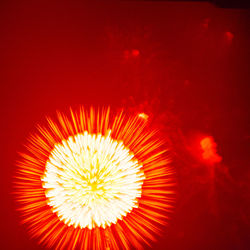 Close-up of illuminated fireworks against orange sky