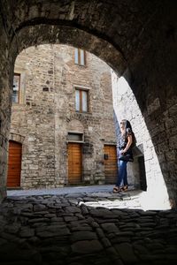 Woman standing below arch in city