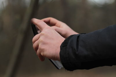 Cropped hands of man photographing with smart phone