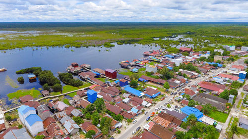 High angle view of houses by sea against sky