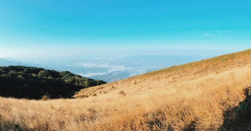 Scenic view of landscape and mountains against blue sky