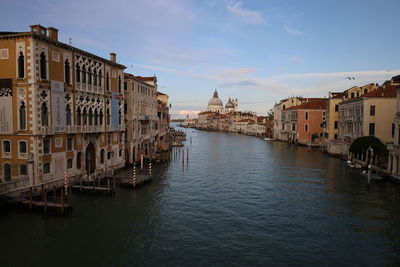 Canal amidst buildings against sky