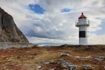 Lighthouse by sea against sky