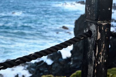 Close-up of fence against sea