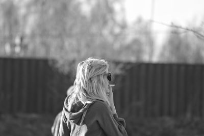 Young woman smoking cigarette in park