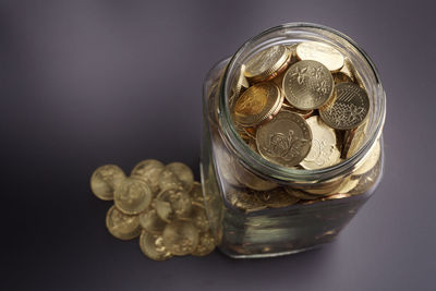 High angle view of coins in glass jar on table