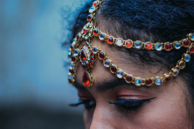 Close-up of woman wearing make-up and jewelry