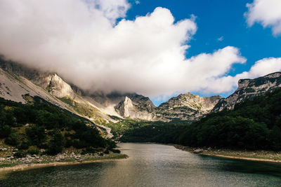 Scenic view of river amidst mountains against sky