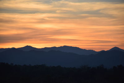 Scenic view of silhouette mountains against sky at sunset