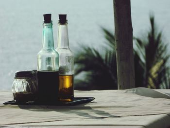 Close-up of liquids and pepper shaker on table