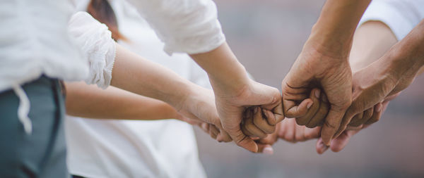 Midsection of people holding hands