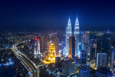 Illuminated cityscape against sky at night