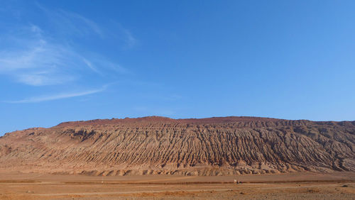 Scenic view of desert against blue sky