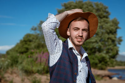 Young man in a hat on nature looks to the side