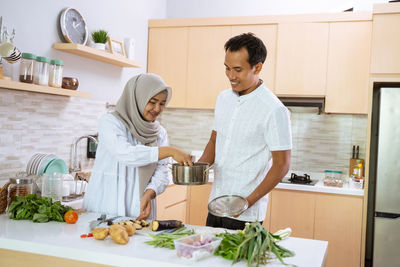 Man and woman standing in kitchen at home