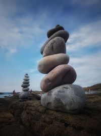 Stack of stones on beach against sky