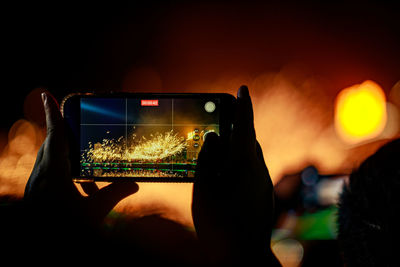 Girl capturing molten iron flower show with her phone