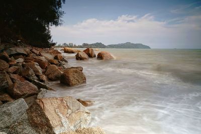 Beautiful scenic view of rocks in sea against sky